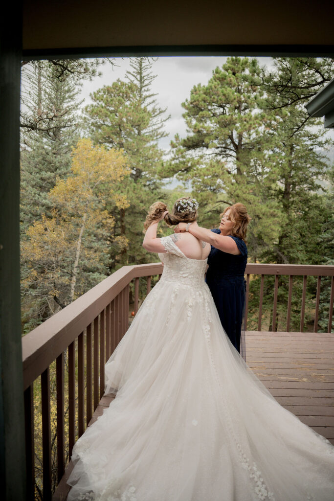 Olivia's bridesmaids helping her with necklace